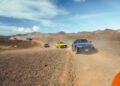 A convoy of colorful SUVs, including the Urus SE, drives on a dusty, rocky dirt road through an arid, mountainous Lanzarote landscape under a blue sky.