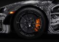 Close-up of a sports car's front wheel with black alloy rims, orange brake caliper, and artistic black-and-white graphic wrap—Project Viva Revealed: One-of-One McLaren 750S Spider Brings Las Vegas to Life in bold detail.