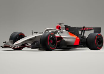 A silver and black Audi R26 concept Formula 1 race car featuring red accents, Pirelli tires, and Audi branding, shown on a plain gray background—ready for its Formula 1 debut in Melbourne.