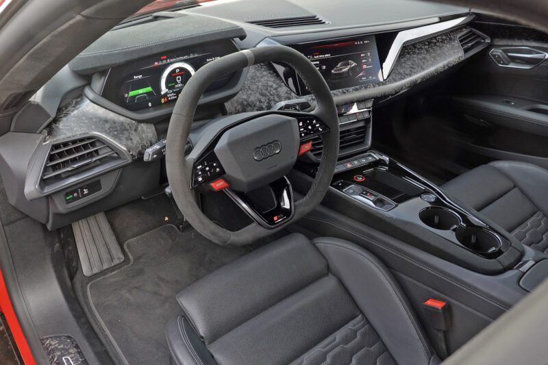 Close-up view of the 2025 Audi RS e-tron GT Performance interior featuring a digital dashboard, multifunction steering wheel, center console, and leather seats. Review: Experience cutting-edge design and advanced technology firsthand.