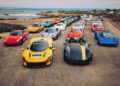 A group of high-performance sports cars, including Ferraris, Pagani, and Porsche models, line a coastal road—an impressive scene as the U.S. luxury automotive market is set to surpass $200 billion by 2035, according to a comprehensive BCG study.
