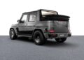 Matte black Brabus G-Class SUV with the roof retracted, rear view, parked on a gray textured surface with a white background. Inspired by the Brabus Debuts 800 Cabrio and XL 800 Cabrio, it exudes bold luxury and open-air performance.