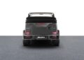 Rear view of a black Brabus G-Class convertible, inspired by the Brabus Debuts 800 Cabrio, parked on a flat, dark surface with the soft top down and tail lights illuminated.