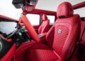 Interior of a luxury vehicle, inspired by the Brabus Debuts 800 Cabrio, featuring red quilted leather seats, a red steering wheel, and high-end finishes with a digital dashboard display.