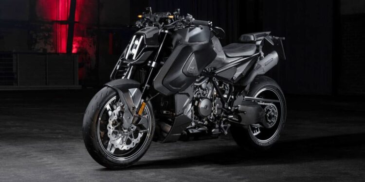 A matte black BRABUS 1400 R Signature Edition sport motorcycle is parked indoors on a concrete floor, with a dim background and red light illuminating the wall behind it, hinting at its exclusive 2026 allure.