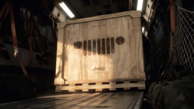 A large wooden crate with the Jeep logo and grille design is secured inside a cargo aircraft—marking the first of 12 as Jeep launches its 85th Anniversary Limited Edition Series with the Moab 392.