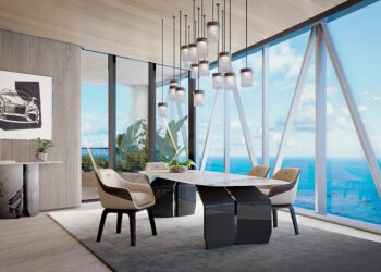 Modern conference room with a marble table, six chairs, pendant lights, large windows revealing an ocean view—echoing the luxury of Miami penthouses in Bentley Residences—with a plant and car artwork on the wall.