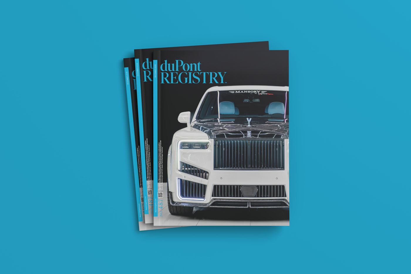 A stack of December 2025 duPont REGISTRY magazines featuring a white luxury SUV with a prominent grille on the cover, set against a blue background.