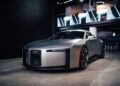 A silver Audi Concept C with a sleek, futuristic design is displayed indoors on a polished concrete floor under modern lighting in London.