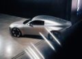 A sleek, silver Audi Concept C with a modern, aerodynamic design is parked indoors on a concrete floor under dramatic lighting, capturing the innovative spirit of London.
