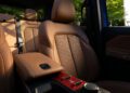Brown leather front seats and center console of the all-electric 2026 Jeep Recon, with sunlight streaming in and green trees visible through the windows, create a trail-ready interior perfect for any adventure.
