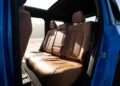 Brown leather back seats inside the 2026 Jeep Recon, an All-Electric blue vehicle with an open door, ample legroom, and sunlight streaming through the window. Trail-Ready comfort meets modern style for your next adventure.