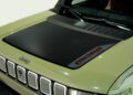 Close-up of a trail-ready, light green 2026 Jeep Recon's hood featuring a black matte decal with "MOAB" lettering in red and gray accents.