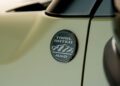 Close-up of a metallic "Trail Rated 4x4" badge with mountain graphic on the side of a trail-ready, all-electric 2026 Jeep Recon.