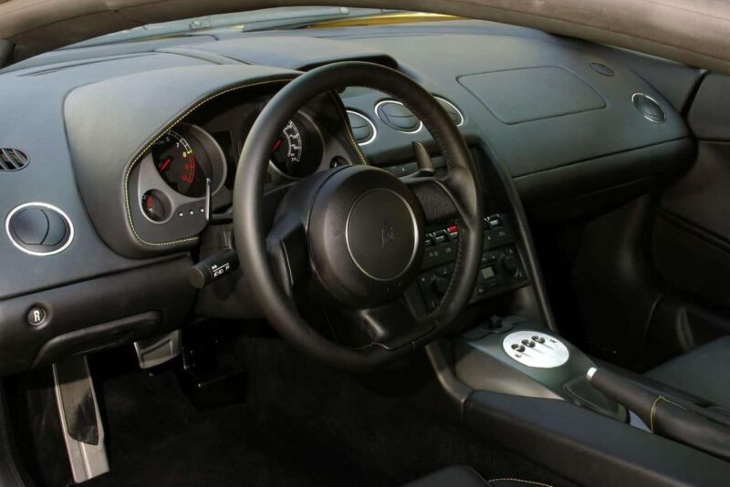 Paskutinio „Lamborghini“ su galinių ratų pavara ir mechanine pavarų dėže interjere – juodas vairas, analoginiai matuokliai, centrinė konsolė su valdikliais, odinės sėdynės.