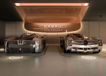 Two silver Pagani Utopia Roadster sports cars are parked side by side in a modern garage labeled "Pagani Residences," featuring numbered parking spots 16 and 19 beneath the ultra-rare penthouses above.