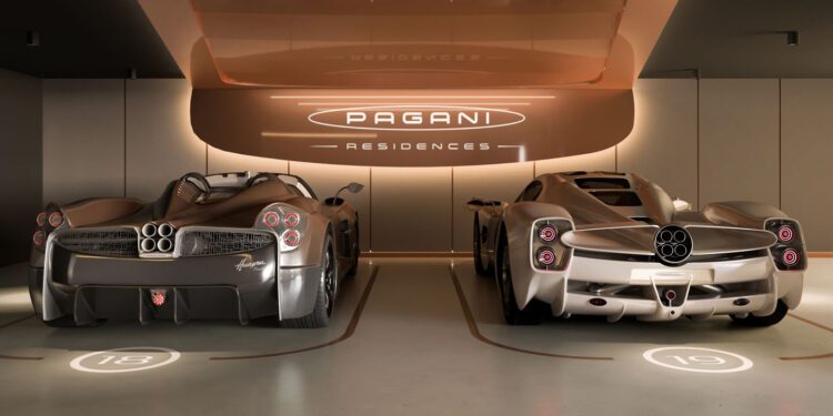 Two silver Pagani Utopia Roadster sports cars are parked side by side in a modern garage labeled "Pagani Residences," featuring numbered parking spots 16 and 19 beneath the ultra-rare penthouses above.
