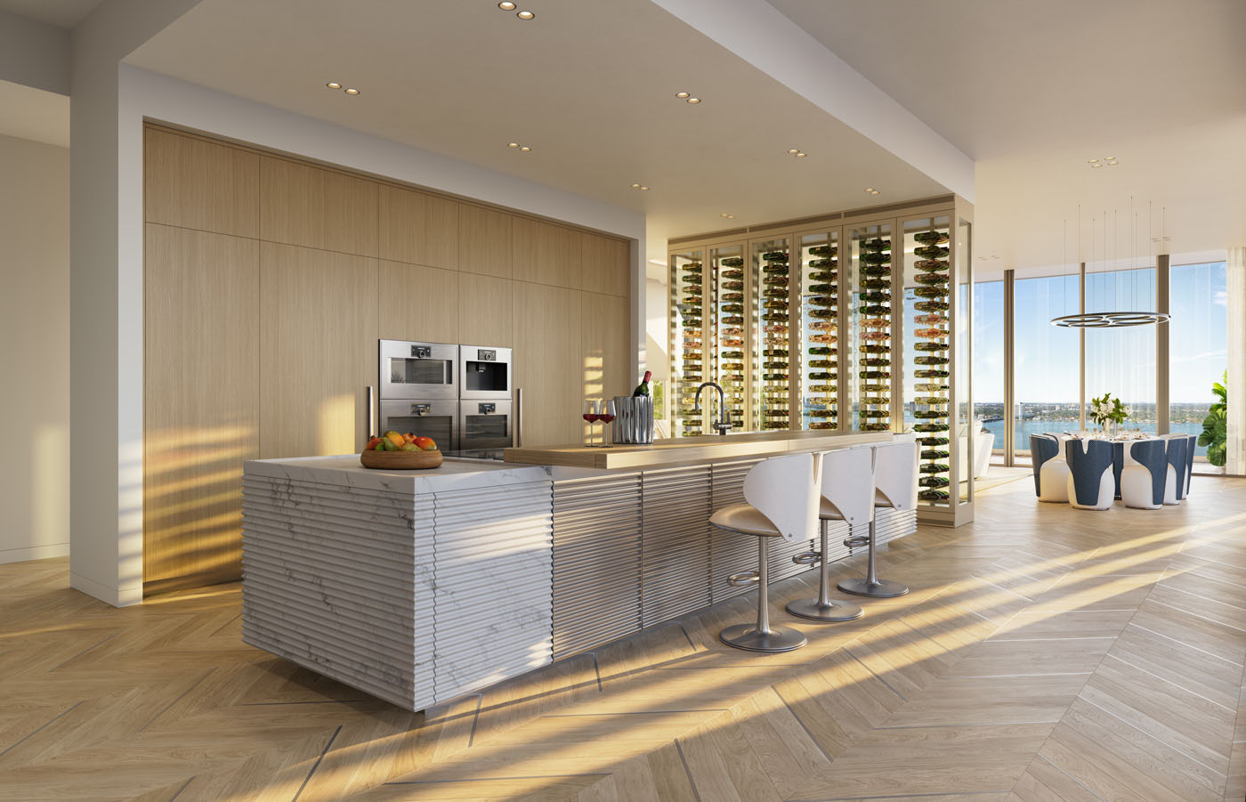 Modern kitchen in one of the Ultra-Rare Penthouses, featuring a large island, three bar stools, built-in ovens, floor-to-ceiling wine racks, and expansive windows with a stunning view.