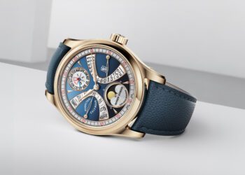 A luxury wristwatch with a blue leather strap, gold casing, and a detailed multi-function dial displaying a moonphase, calendar, and other indicators.