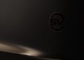A close-up of a dark surface featuring an embossed "SV" logo, with soft lighting creating subtle reflections and shadows—a nod to the SV Black Range Rover's luxury features.
