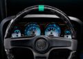 Close-up of a car's steering wheel and illuminated dashboard, featuring blue-lit gauges—reminiscent of the cutting-edge style seen in the Ringbrothers' 800-plus horsepower 1969 Ford Mustang Mach 1 'KINGPIN' unveiled at 2025 SEMA.