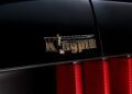 Close-up of a gold "Kingpin" emblem with a sword and chess piece design on the back of a black car, above red tail lights—celebrating the Ringbrothers’ unveiling of their 800-plus horsepower 1969 Ford Mustang Mach 1 'KINGPIN' at 2025 SEMA.