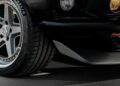 Close-up of a car’s front left wheel and bumper, showing a Michelin tire, a silver alloy rim, and part of the headlight on a black vehicle—evoking the bold stance of Ringbrothers' 800-plus horsepower 'KINGPIN' Mustang Mach 1 unveiled at SEMA 2025.