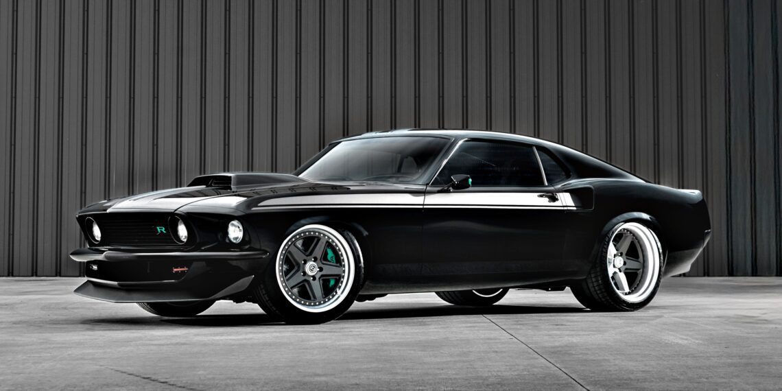 A black classic Ford Mustang with custom modifications, reminiscent of the Ringbrothers' 800-plus horsepower 1969 Mach 1 'KINGPIN' unveiled at the 2025 SEMA, is parked in front of a gray corrugated metal wall.