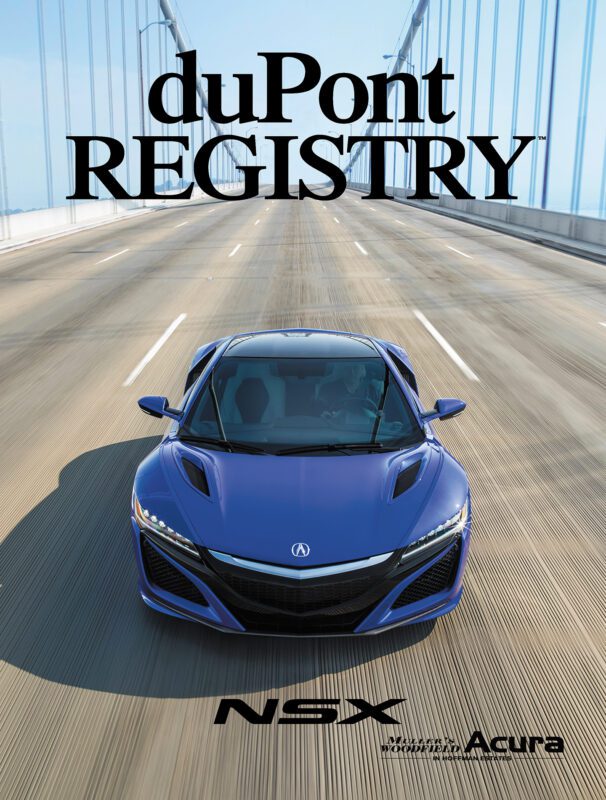 A blue Acura NSX drives on a bridge, featured as one of the 40th Anniversary Cover Cars on the duPont REGISTRY magazine.