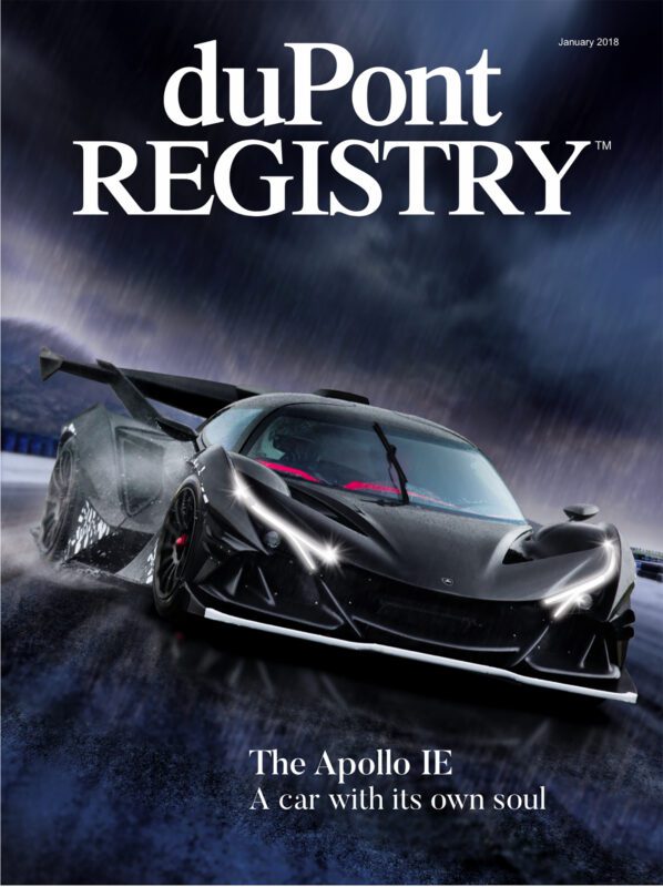A black Apollo IE car drives on a wet road under a cloudy sky, featured as one of the iconic Cover Cars on the January 2018 duPont REGISTRY magazine.