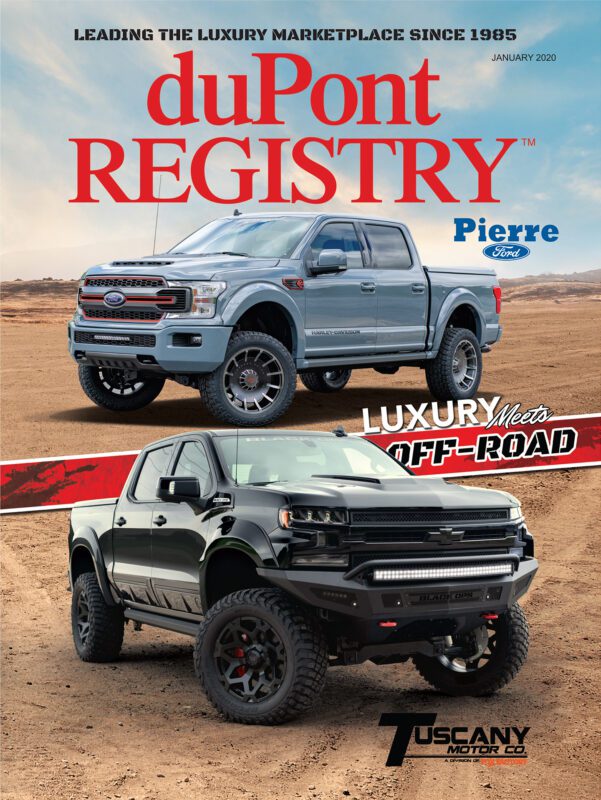 40th Anniversary Cover Cars grace the duPont REGISTRY magazine, featuring two lifted Ford pickup trucks—one silver, one black—strikingly showcased in a desert landscape.
