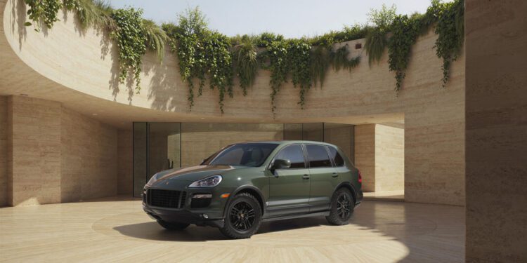 A green Porsche Sonderwunsch SUV is parked in the center of a circular open courtyard with beige stone walls and greenery above.