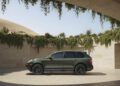 A green 2009 Cayenne GTS is parked in a modern, open-air structure with hanging greenery and a desert landscape in the background, showcasing its Transformed Manual build and Porsche Sonderwunsch exclusivity.