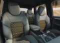 The interior of this 2009 Cayenne showcases two-tone leather seats with a checkered pattern, a central armrest, and visible dashboard controls—hinting at the bespoke craftsmanship found in Porsche Sonderwunsch models.
