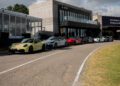 Several Porsche sports cars are parked in a line outside a modern building at the Porsche Driving Center Mexico.