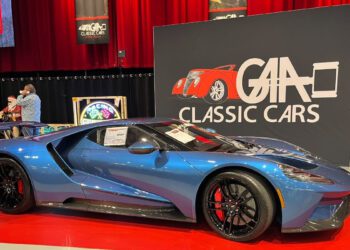 A blue Ford GT sports car is displayed indoors at a classic car show, parked in front of a sign that reads "GAA Classic Cars.