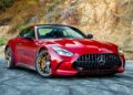 A red 2025 Mercedes-AMG GT63 S E Performance sports car is parked on a paved surface in front of a rocky hillside.