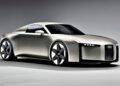 A silver Audi concept car from 2025 with a sleek, futuristic design, angular lines, narrow headlights, and large black-and-silver wheels is showcased in a studio setting.