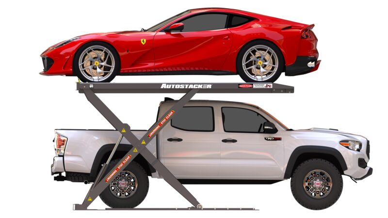 A red sports car is parked on an elevated Autostacker lift above a white pickup truck, making the most of limited garage space.
