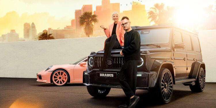 Two people pose with luxury cars in an urban setting; one sits on the hood of a black BRABUS SUV, while the other stands in front—capturing a ONE SECOND WOW moment with a pink sports car and city skyline in the background.
