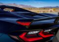 Close-up of the rear of a black sports car with red tail lights and a rear spoiler labeled "Z06," parked outdoors with mountains in the background—part of Chevy Honors America’s 250th Anniversary With Ultra-Exclusive Stars & Steel Collection.