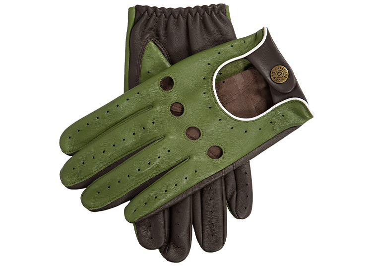 A pair of green and brown leather driving gloves with perforations and a snap button closure on the wrist, perfect for any car enthusiast’s 2026 Holiday Gift Guide featured in duPont REGISTRY.