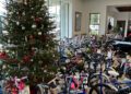 A decorated Christmas tree stands next to rows of new children's bicycles arranged indoors, each with a gift tag, as part of the Dimmitt Automotive Group's Toys for Tots drive.