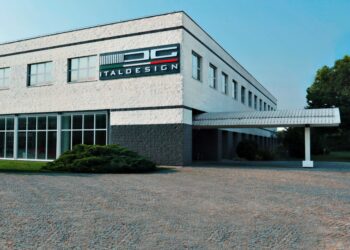 A modern two-story building with large windows and "Italdesign" signage on the upper corner facade, surrounded by greenery and a cobblestone driveway, now highlights California-based UST takes majority control of Italdesign.