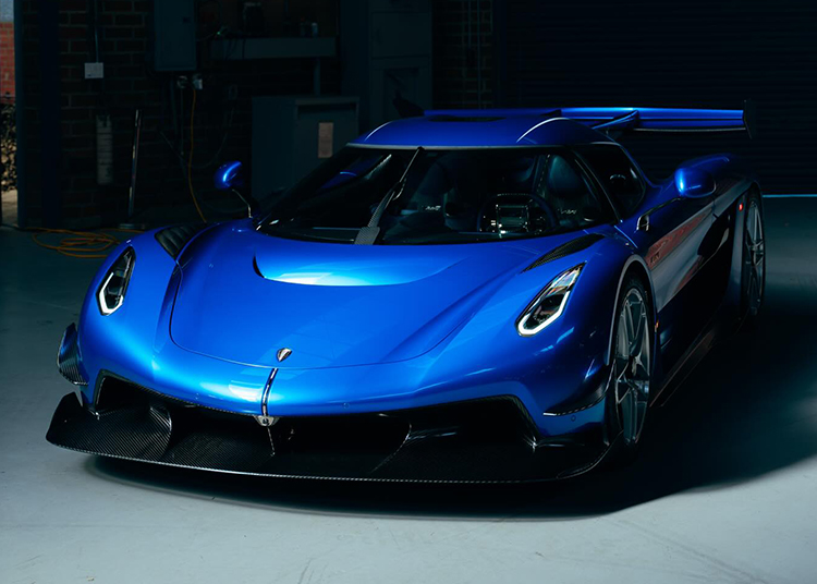 A blue Koenigsegg Jesko hypercar with aerodynamic design features is parked indoors under low lighting, reflecting the exclusivity found at O'Gara Coach.