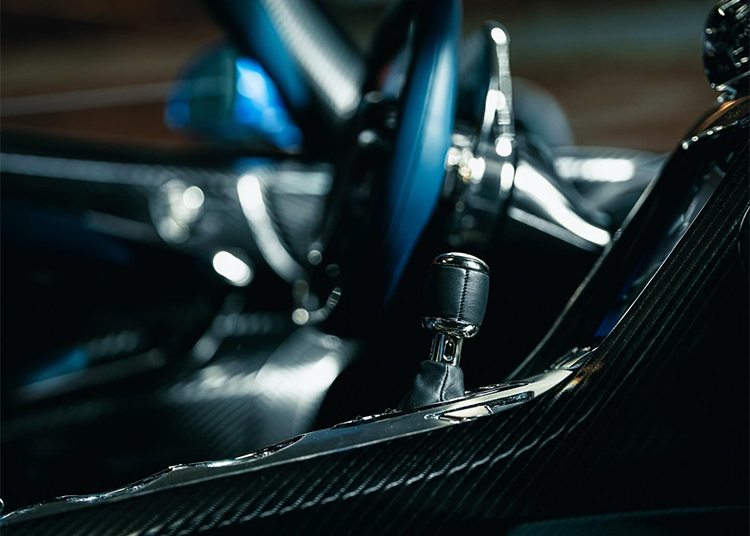 Close-up view of a hypercar’s interior, focusing on the gear shift lever, steering wheel, and carbon fiber detailing—exuding the unmatched luxury of an O'Gara Coach Koenigsegg Jesko.