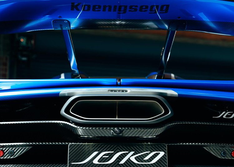 Close-up of the rear section of the hypercar Koenigsegg Jesko, showing the large rear wing, exhaust, and visible carbon fiber details.