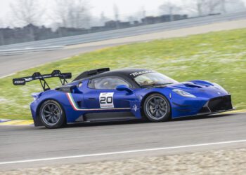A blue Maserati race car with number 20 on the door drives on a racetrack, equipped with a rear wing and racing decals, competing in the 2026 Championship.