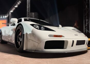 A white sports car with black wheels displayed indoors under bright lights, photographed from a low front angle—Feature Exclusive: $25.3M McLaren F1 leads RM Sotheby's Abu Dhabi Auction.