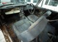The interior of this rare DB5 reveals an old, heavily rusted car with torn seats, loose wires, and significant decay on the dashboard and floor—a true restoration project for Aston Martin Works.